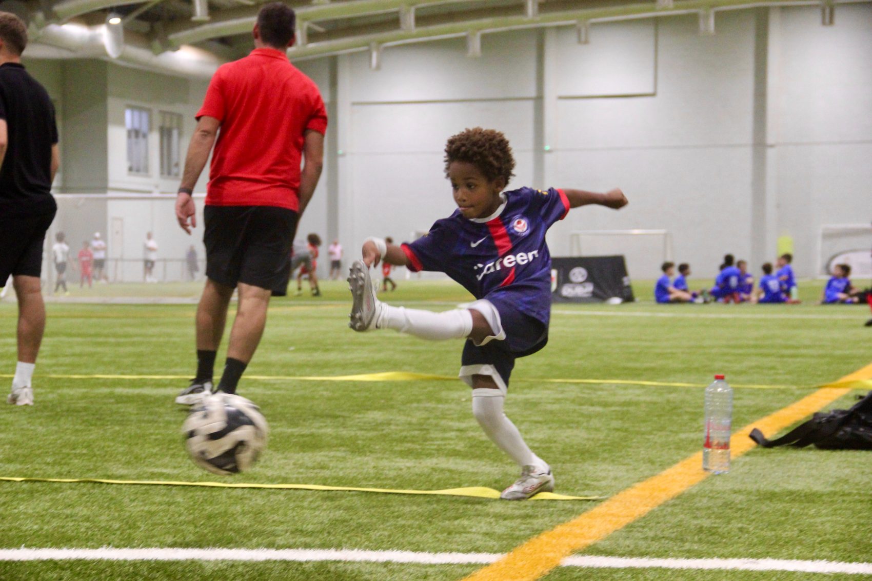 Young EPIC player striking the ball during indoor football training in Dubai
